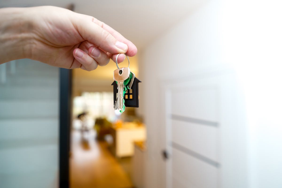 Real estate agent holding house keys inside a modern apartment
