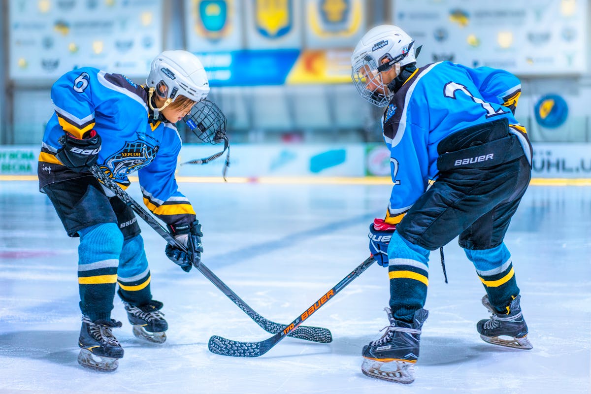 Two young hockey players facing off at centre ice