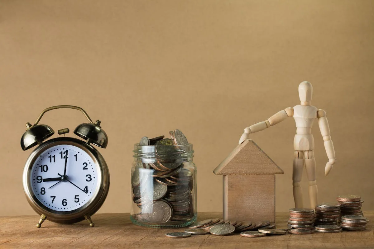 Clock, coins and house model representing financial planning and budgeting