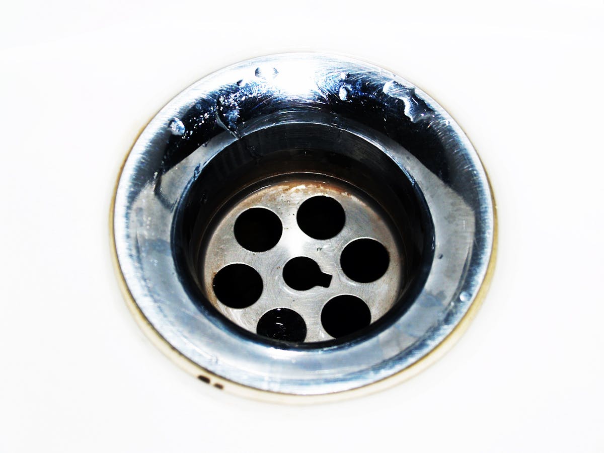 Close-up of stainless steel sink drain - strange plumbing odors source Bayshore Plumbing Belleville
