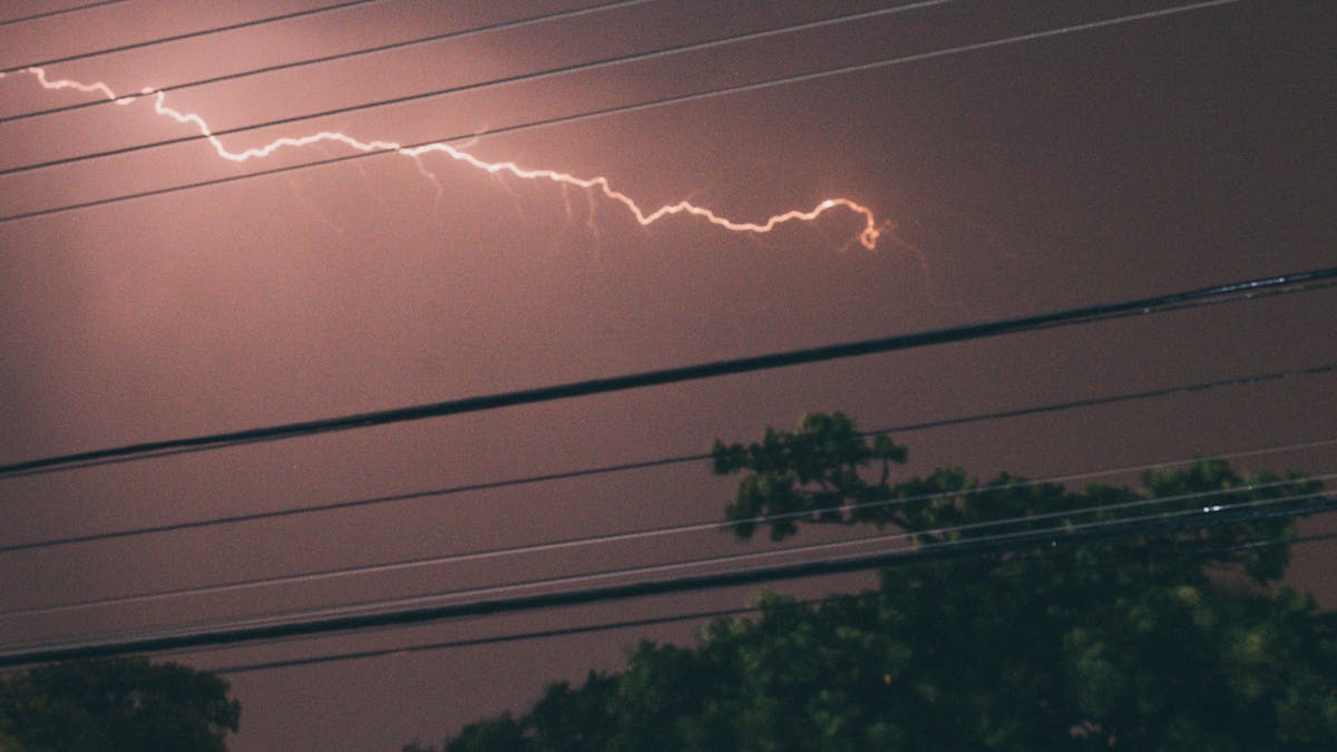 Storm clouds and lightning over power lines - winter power outages Eastern Ontario Briden Electrical generators